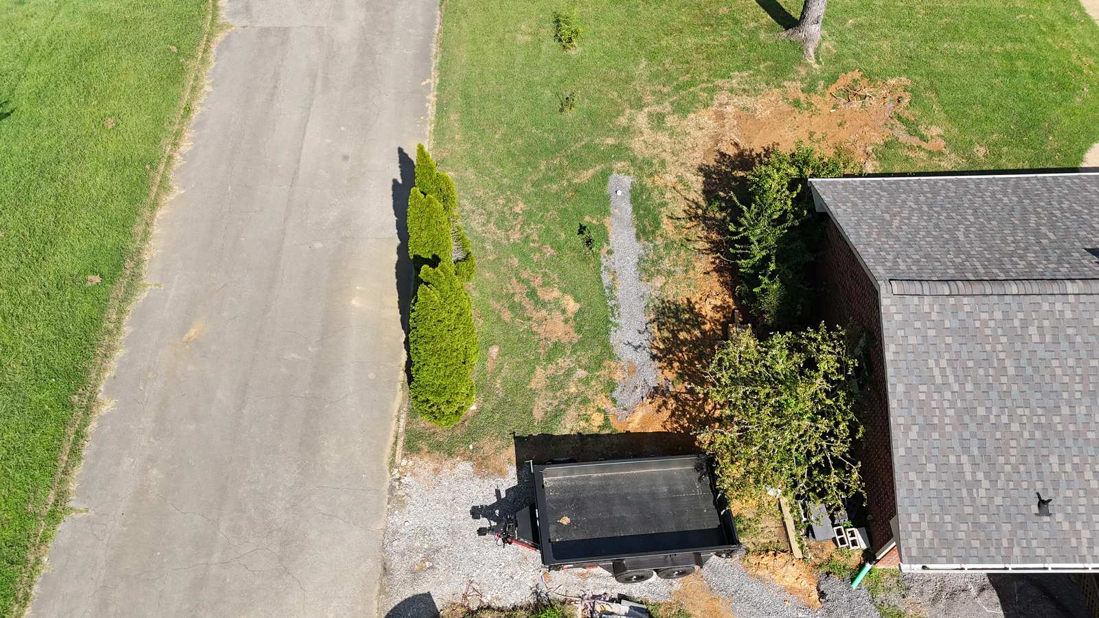 Aerial of a finished gravel drainage trench in a lawn.
